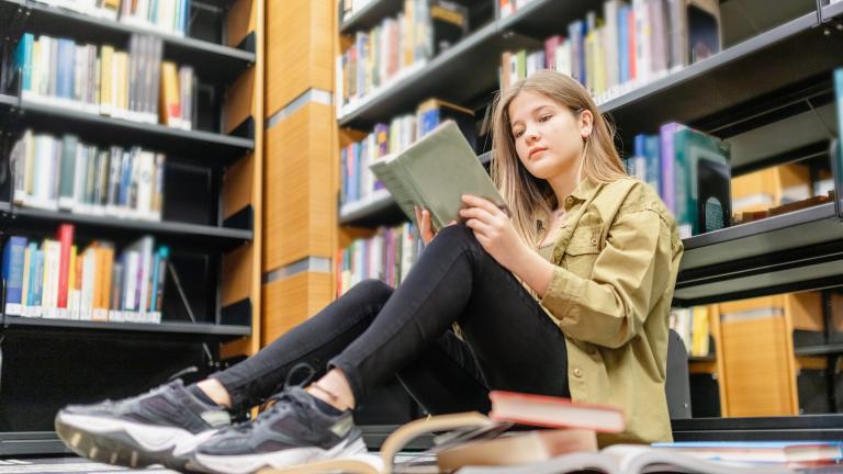 Girl reading a book in a shop